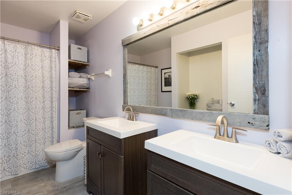 17401 Butler Road Fort Myers, FL 33967 - Photo 18 of 22 a bathroom with a sink toilet double vanity and shower