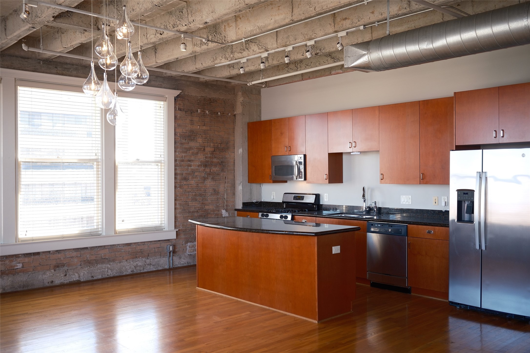 a kitchen with granite countertop a sink stainless steel appliances and cabinets