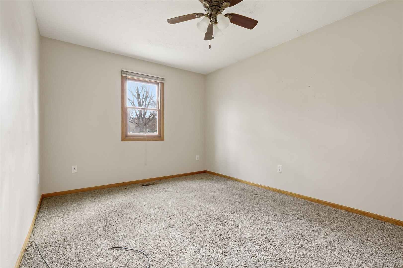 409 East Delaware Street Dwight, IL 60420 - Photo 15 of 31 an empty room with a window and a ceiling fan