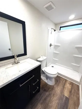 a bathroom with a granite countertop sink toilet and shower