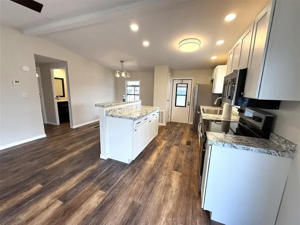 a large kitchen with stainless steel appliances kitchen island a large counter tops and a stove
