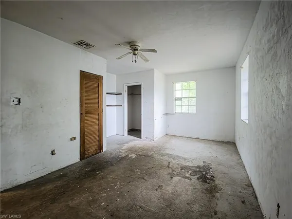 an empty room with windows and closet