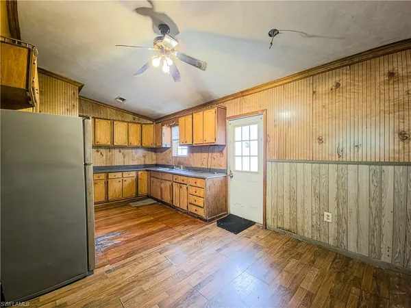 a view of a kitchen with wooden floor and a refrigerator