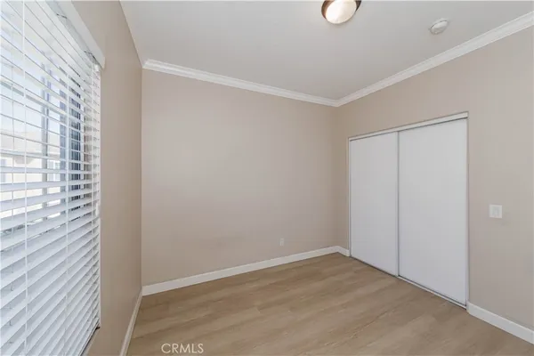 a view of an empty room with wooden floor and windows