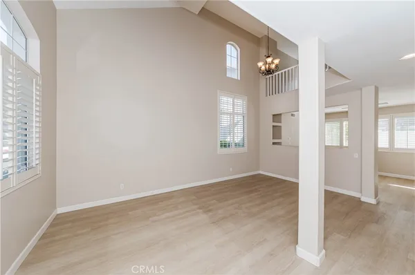 an empty room with windows and wooden floor