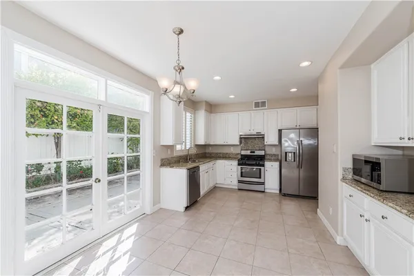 a large kitchen with stainless steel appliances kitchen island granite countertop a large counter top a sink stainless steel appliances and cabinets