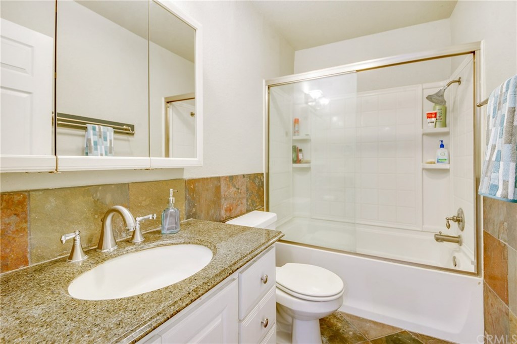 513 D Street, Unit 53 Upland, CA 91786 - Photo 19 of 25 a bathroom with a granite countertop sink toilet mirror and shower