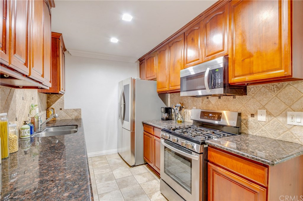513 D Street, Unit 53 Upland, CA 91786 - Photo 8 of 25 a kitchen with stainless steel appliances granite countertop a stove a sink and a refrigerator