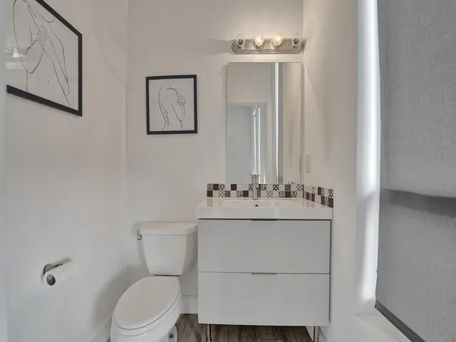 a bathroom with a toilet sink and mirror