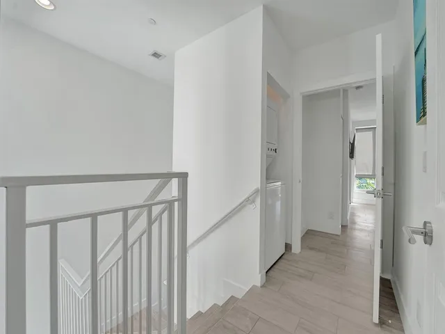 a view of a hallway with a white walls and stairs