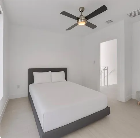 a large bed sitting in a bedroom next to a window