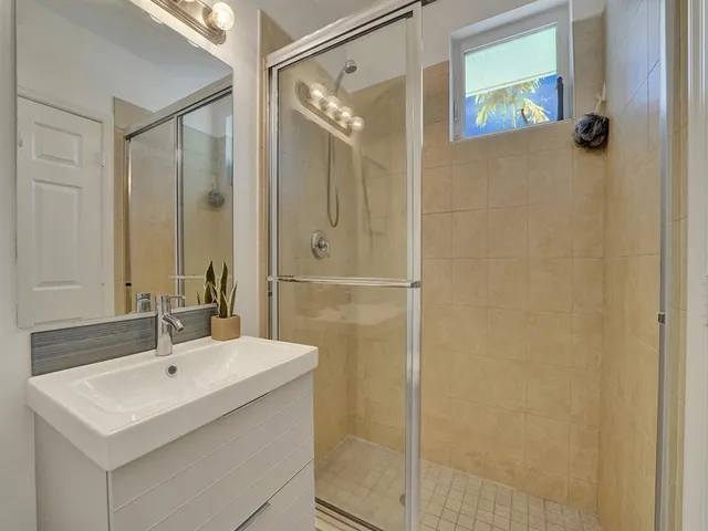 a bathroom with a shower sink and mirror