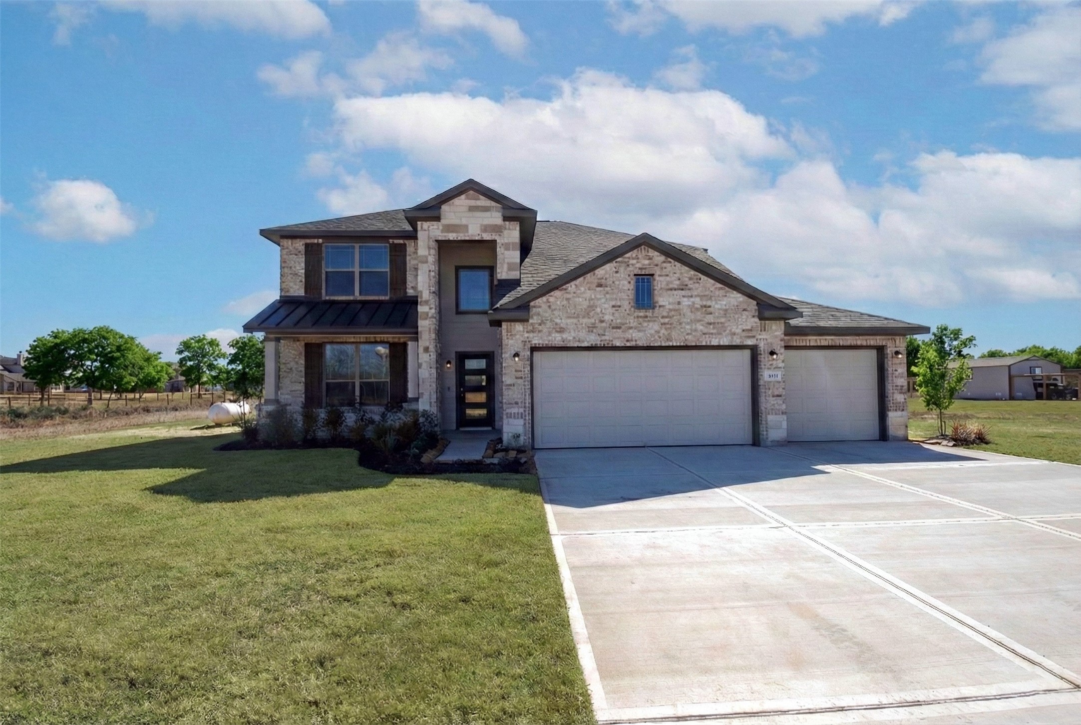 1423 Southfork Ranch Drive Sealy, TX 77474 - Photo 13 of 17 a front view of a house with a garden and plants
