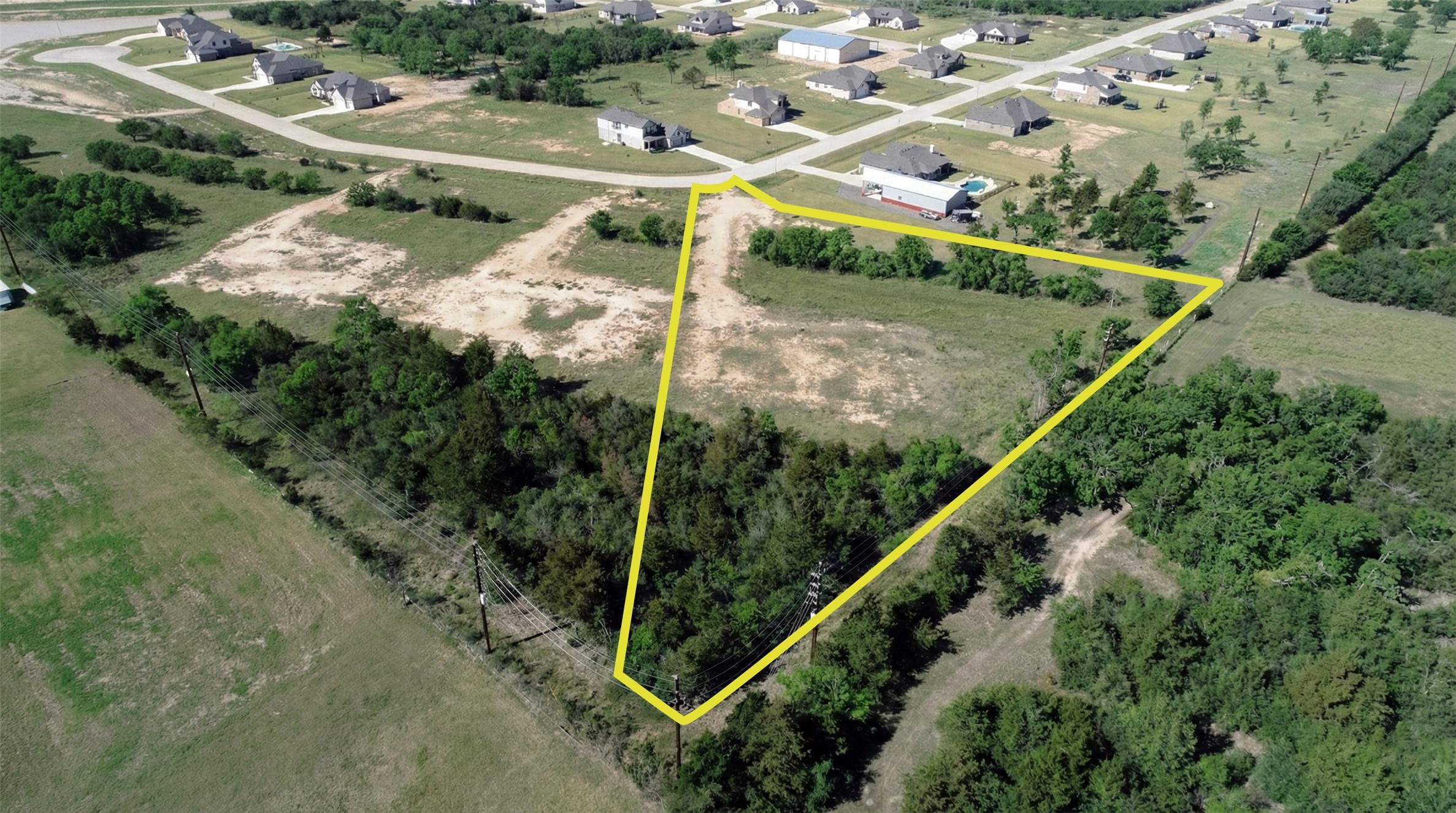 1423 Southfork Ranch Drive Sealy, TX 77474 - Photo 4 of 15 This aerial perspective highlights the surrounding landscape and tree coverage, offering a sense of space and natural privacy.