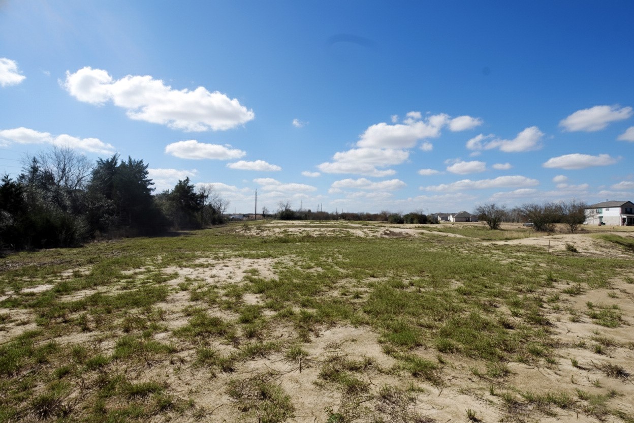 1423 Southfork Ranch Drive Sealy, TX 77474 - Photo 8 of 15 This view captures the openness of the land and the expansive sky, showcasing the property’s peaceful setting.