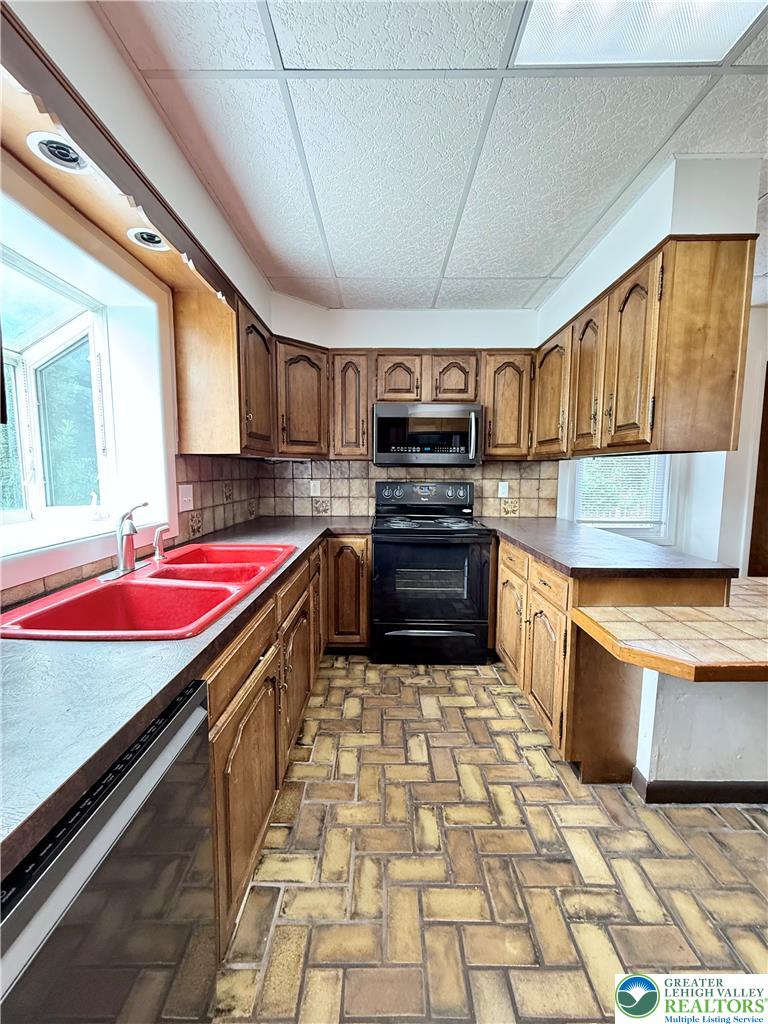 5540 Main Street Whitehall, PA 18052 - Photo 11 of 53 A functional kitchen features rich wood cabinetry and a classic tile floor.