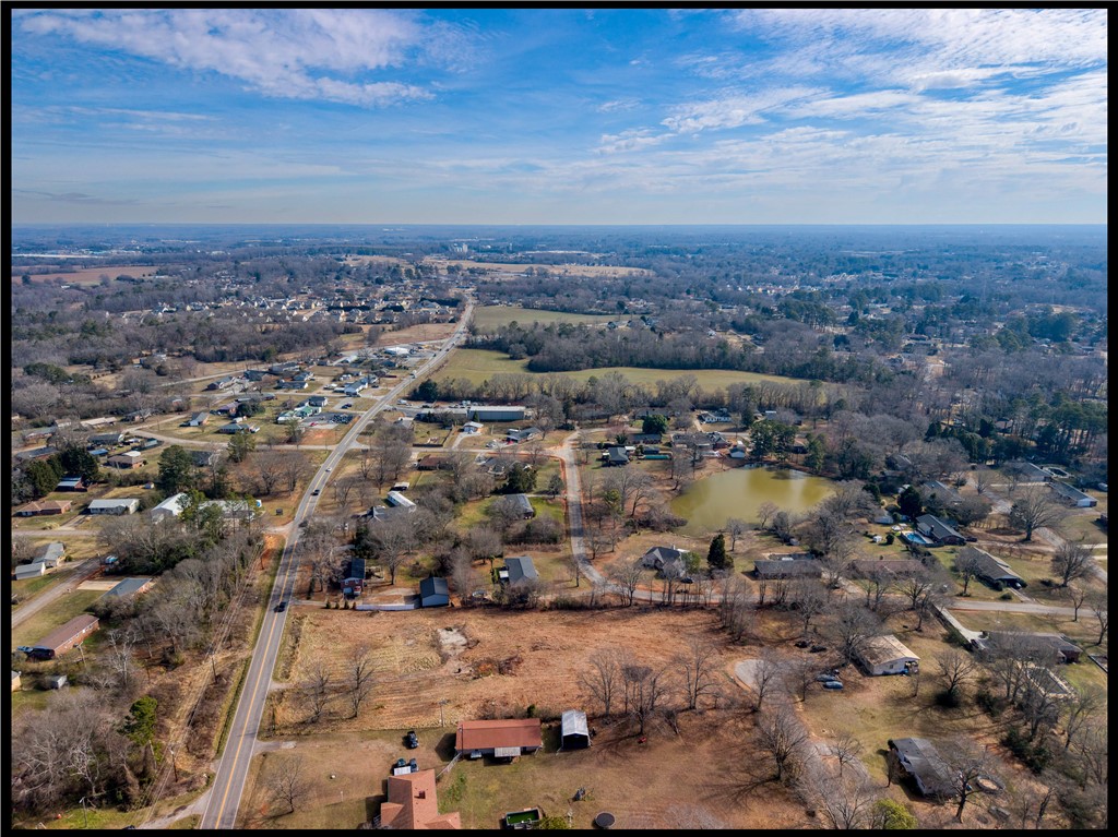 2205 Whitehall Road Anderson, SC 29625 - Photo 2 of 13 An aerial perspective reveals a serene community with a glistening pond under a vast sky.