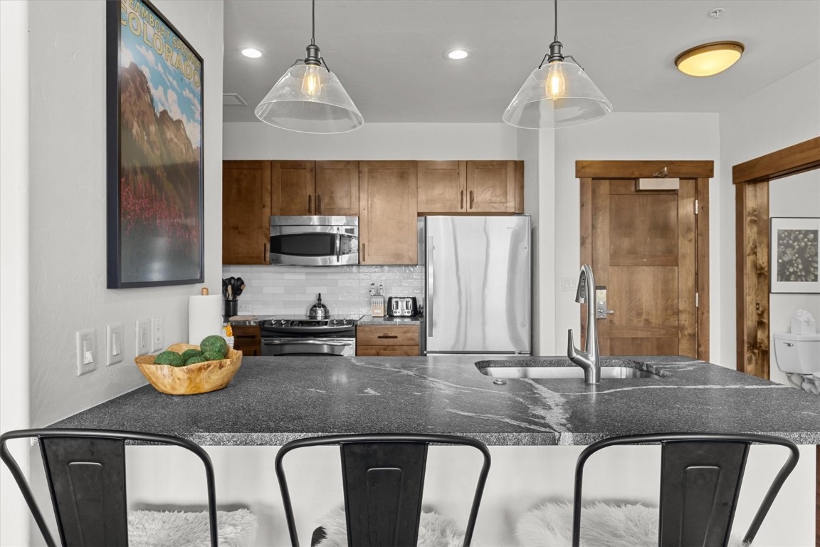 1175 Bangtail Way, Unit 5118 Steamboat Springs, CO 80487 - Photo 11 of 46 a kitchen with furniture a counter space appliances and cabinets