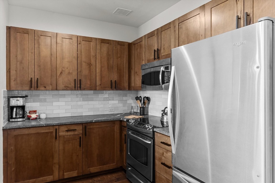 1175 Bangtail Way, Unit 5118 Steamboat Springs, CO 80487 - Photo 12 of 46 a kitchen with stainless steel appliances a refrigerator and a sink