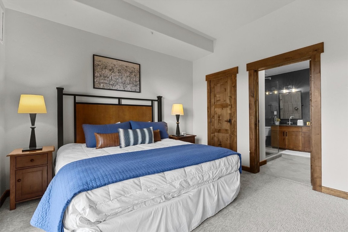1175 Bangtail Way, Unit 5118 Steamboat Springs, CO 80487 - Photo 24 of 46 a bedroom with a bed and a view of bathroom