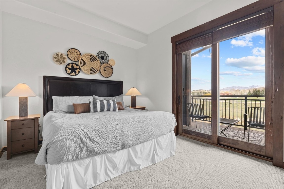 1175 Bangtail Way, Unit 5118 Steamboat Springs, CO 80487 - Photo 27 of 46 a bedroom with a bed and a large window with the outer view