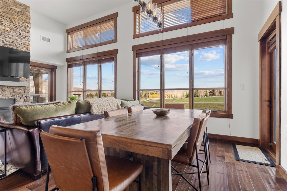 1175 Bangtail Way, Unit 5118 Steamboat Springs, CO 80487 - Photo 7 of 46 a view of a dining room with furniture window and wooden floor