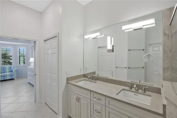 a bathroom with a double vanity sink mirror and shower