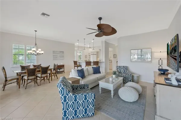 a living room with furniture kitchen view and a chandelier