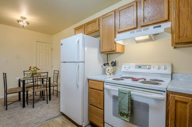 a kitchen with stainless steel appliances a stove a refrigerator and cabinets