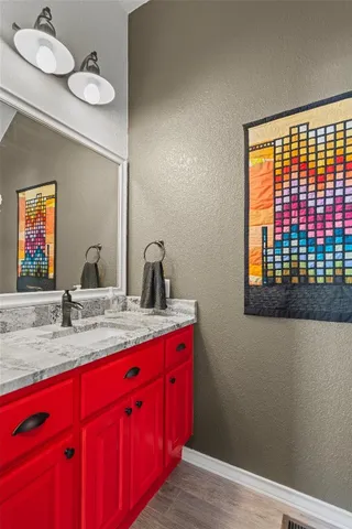 a bathroom with a sink a mirror and wooden floor