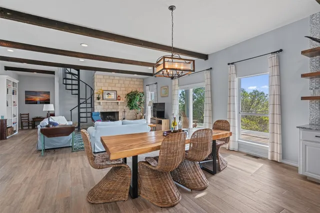 a dining room with wooden floor and windows