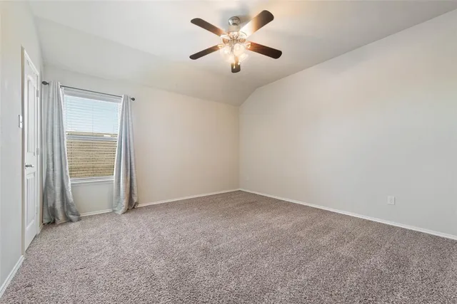 an empty room with closet and a chandelier fan