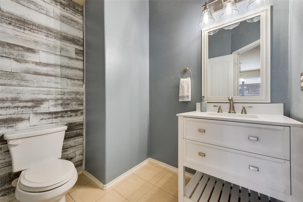2004 Karsen Lane Heartland, TX 75126 - Photo 16 of 18 a bathroom with a sink a toilet a mirror and vanity