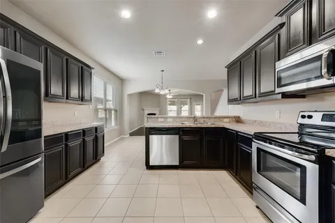 a kitchen with stainless steel appliances granite countertop a stove a sink and a microwave