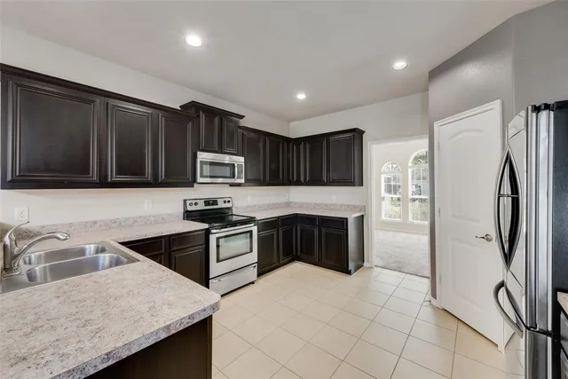 a kitchen with stainless steel appliances granite countertop a refrigerator sink and stove