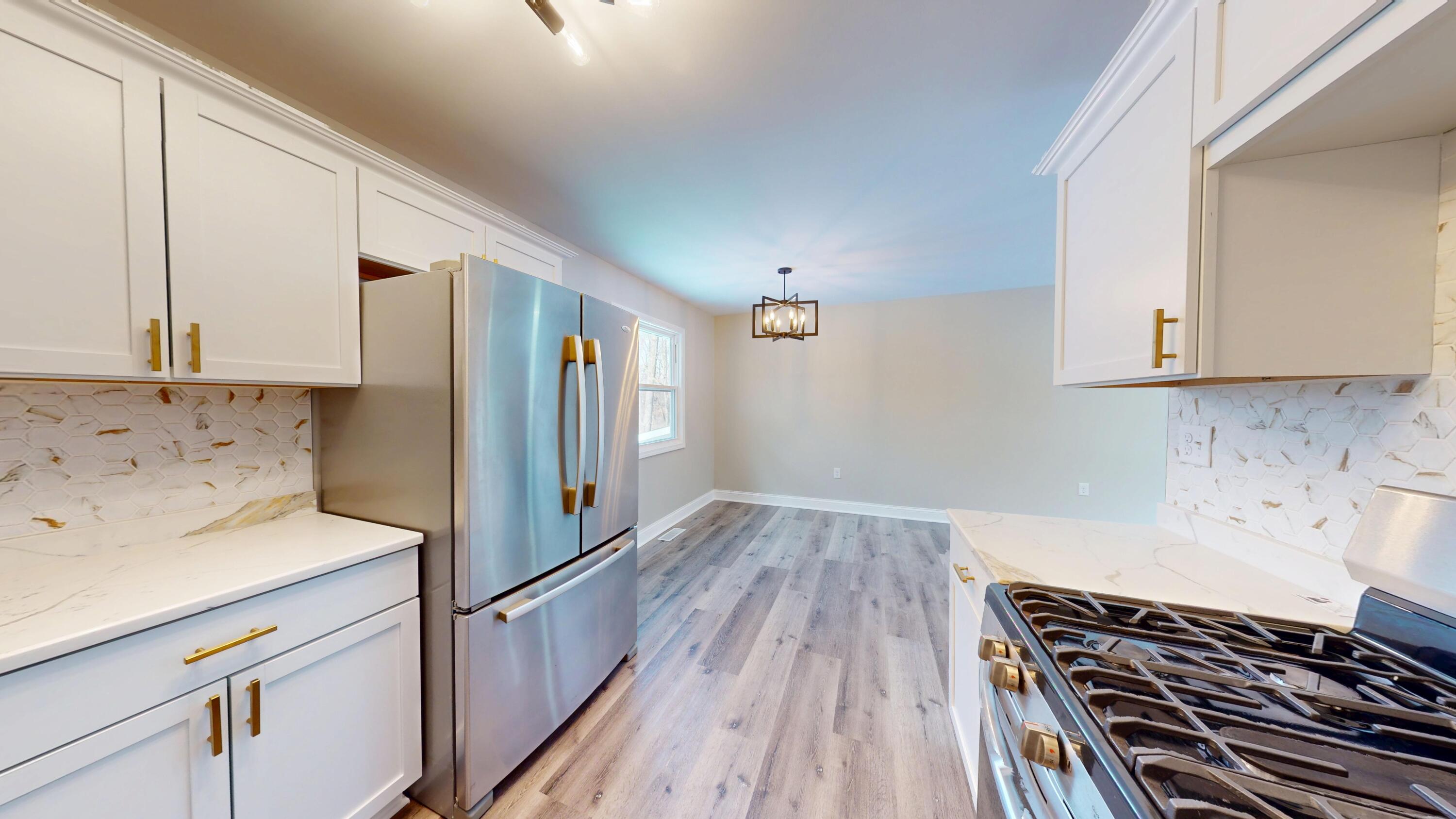1528 Hanley Street Gary, IN 46406 - Photo 28 of 44 a kitchen with wooden floor stove and cabinets