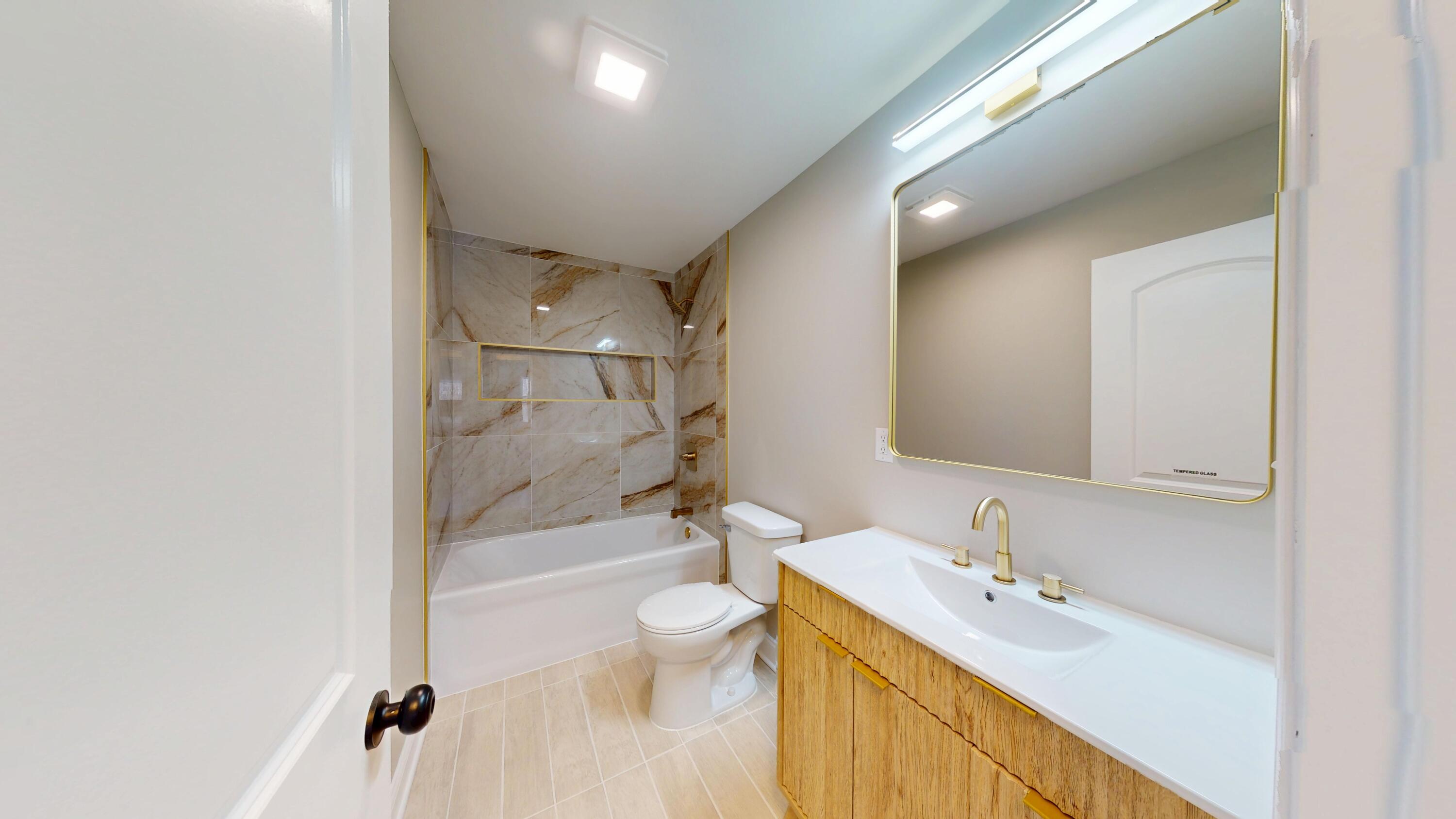 1528 Hanley Street Gary, IN 46406 - Photo 29 of 44 a bathroom with a bathtub shower sink vanity mirror and toilet