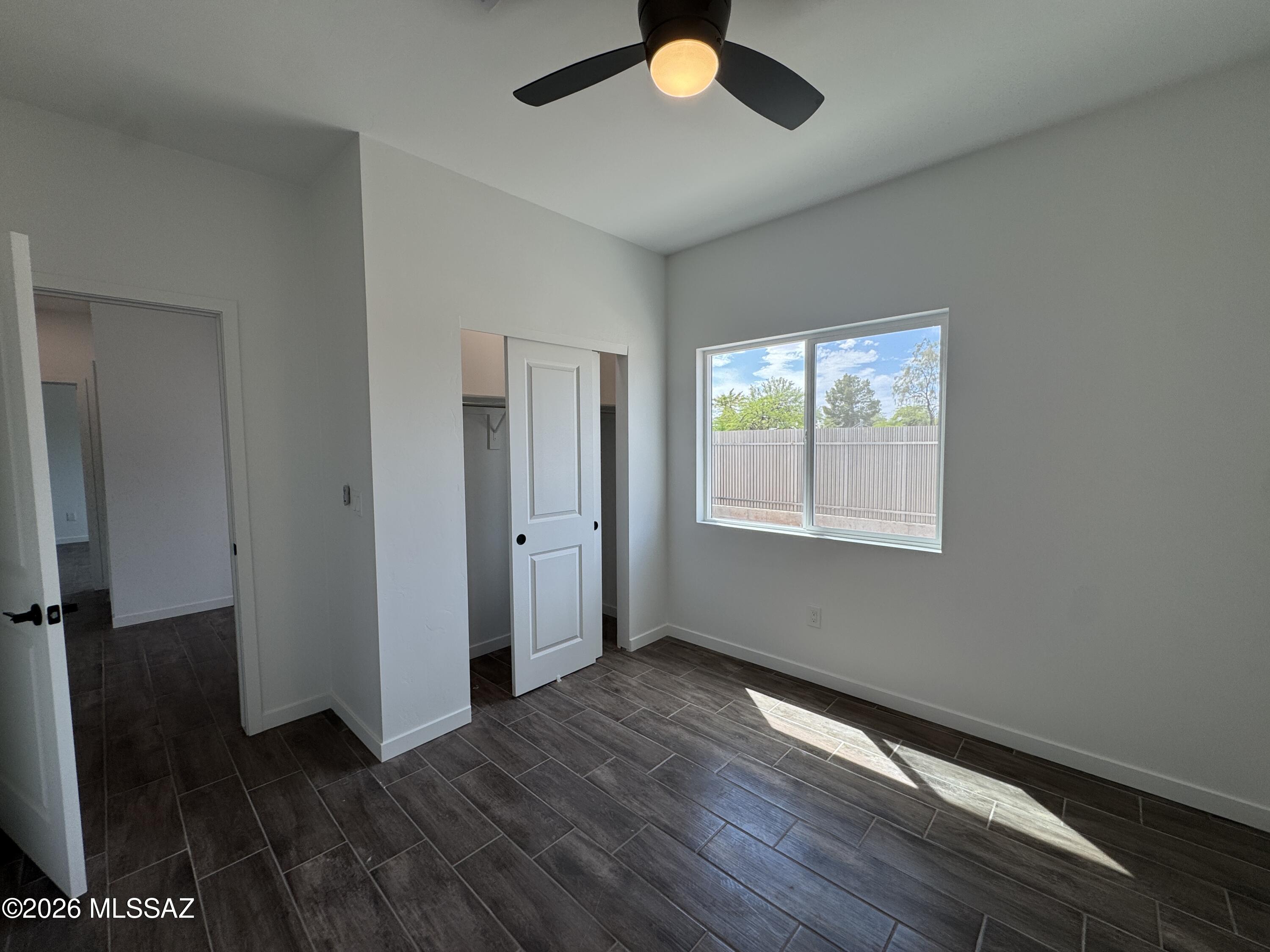2122 North Ralph Avenue, Unit 1 Tucson, AZ 85712 - Photo 4 of 10 a view of an empty room with wooden floor and a window