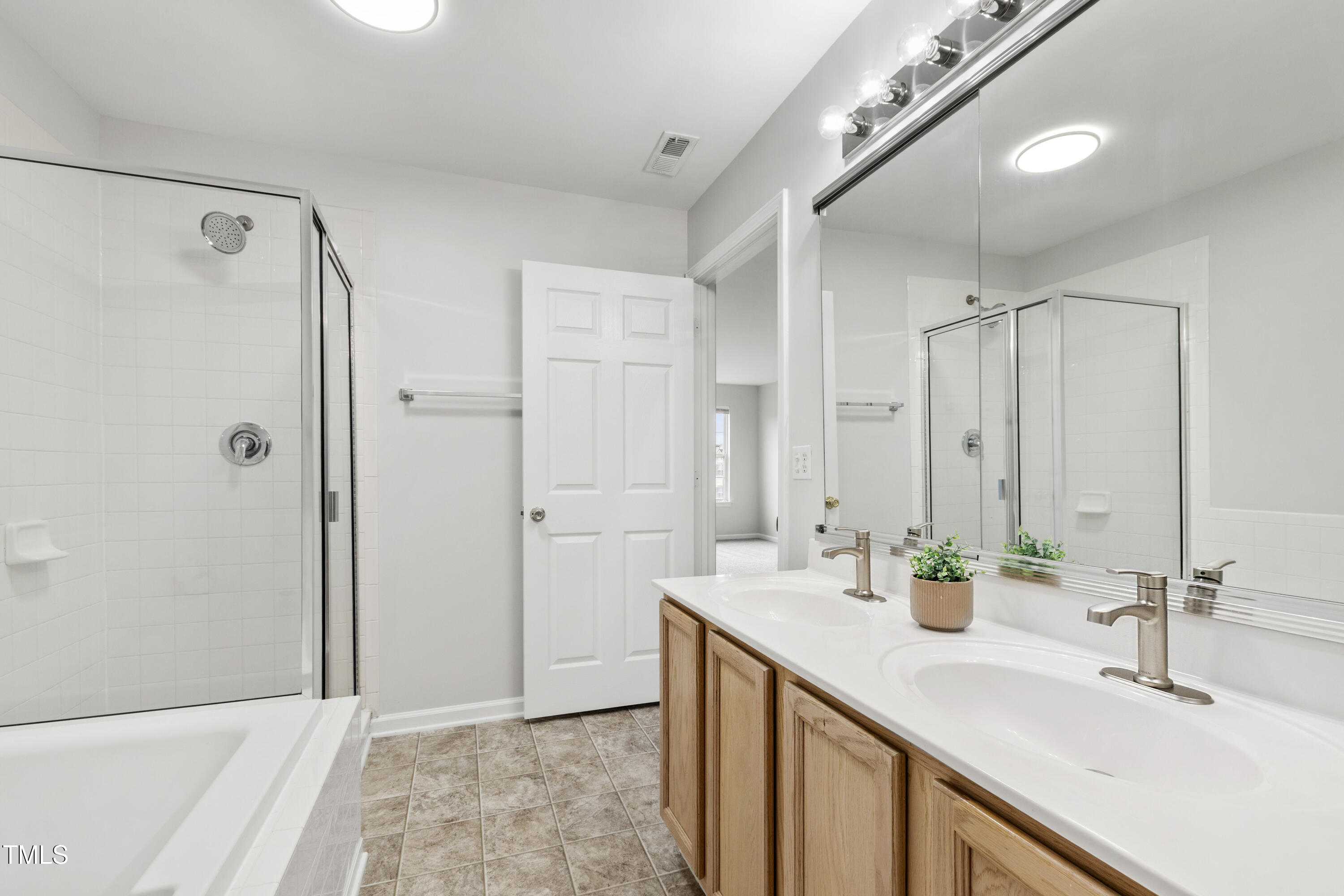 8610 Neuse Landing Lane, Unit 103 Raleigh, NC 27616 - Photo 12 of 28 a bathroom with a double vanity sink mirror and shower