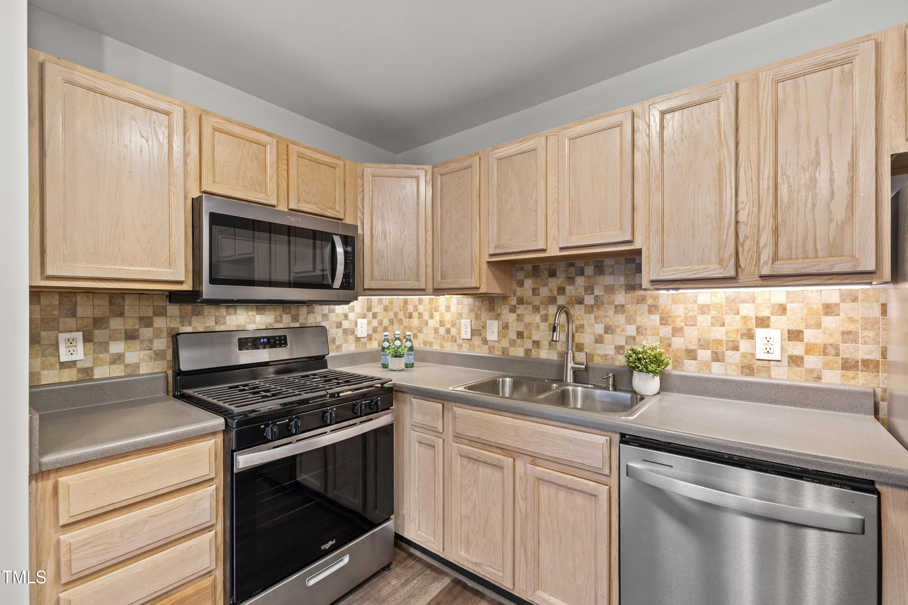 8610 Neuse Landing Lane, Unit 103 Raleigh, NC 27616 - Photo 14 of 28 a kitchen with appliances a sink and cabinets