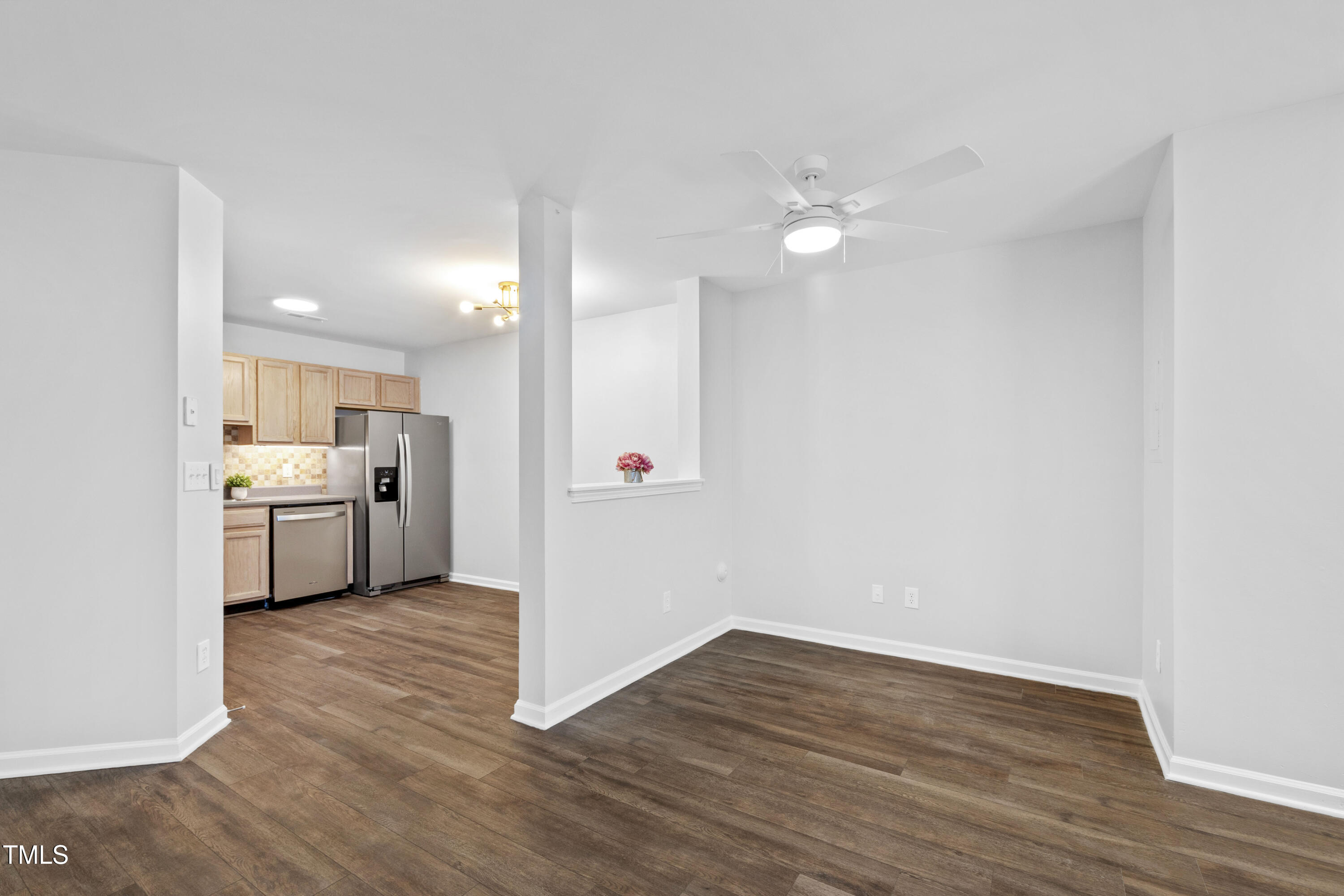 8610 Neuse Landing Lane, Unit 103 Raleigh, NC 27616 - Photo 16 of 28 a view of a kitchen with a sink a ceiling fan and wooden floor