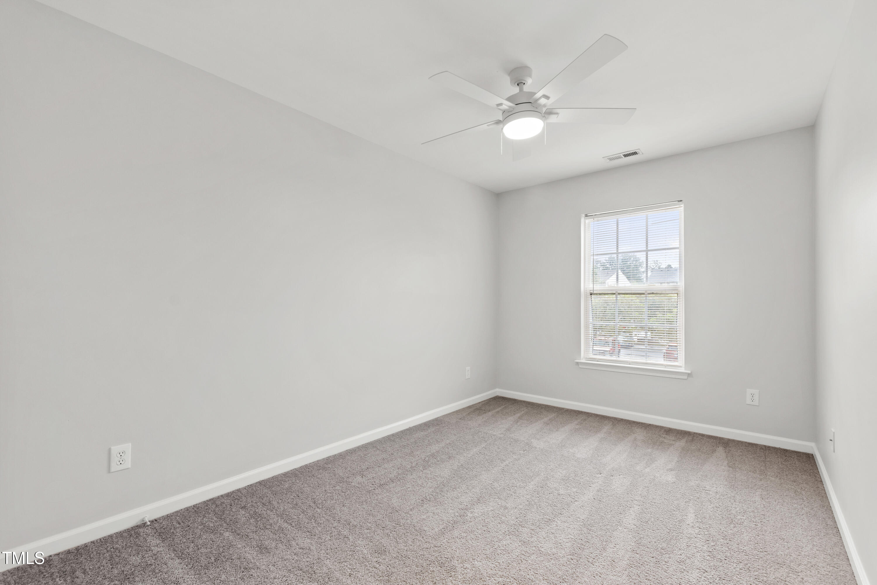 8610 Neuse Landing Lane, Unit 103 Raleigh, NC 27616 - Photo 18 of 28 an empty room with a window and a fan