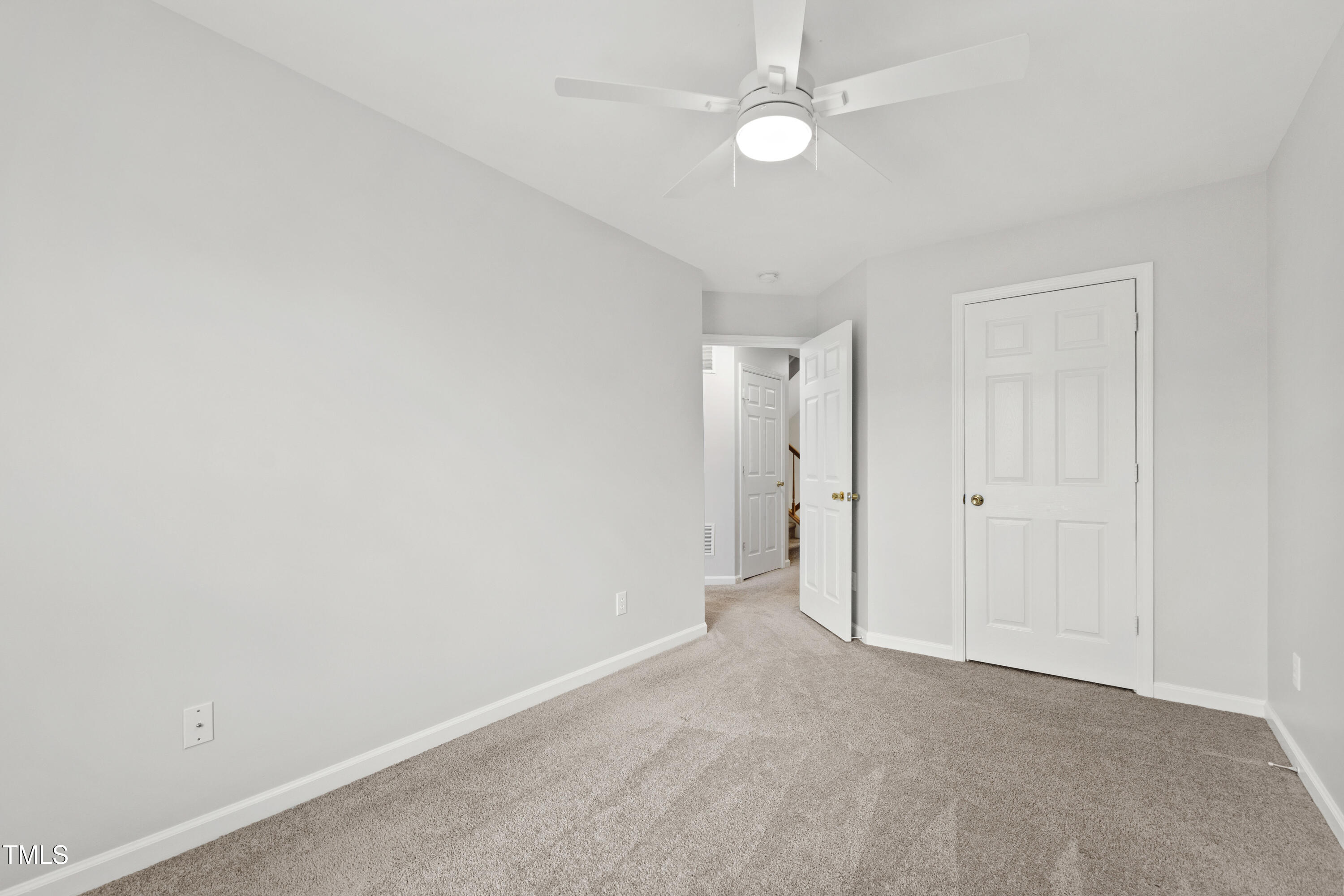 8610 Neuse Landing Lane, Unit 103 Raleigh, NC 27616 - Photo 19 of 28 an empty room with a ceiling fan and a window