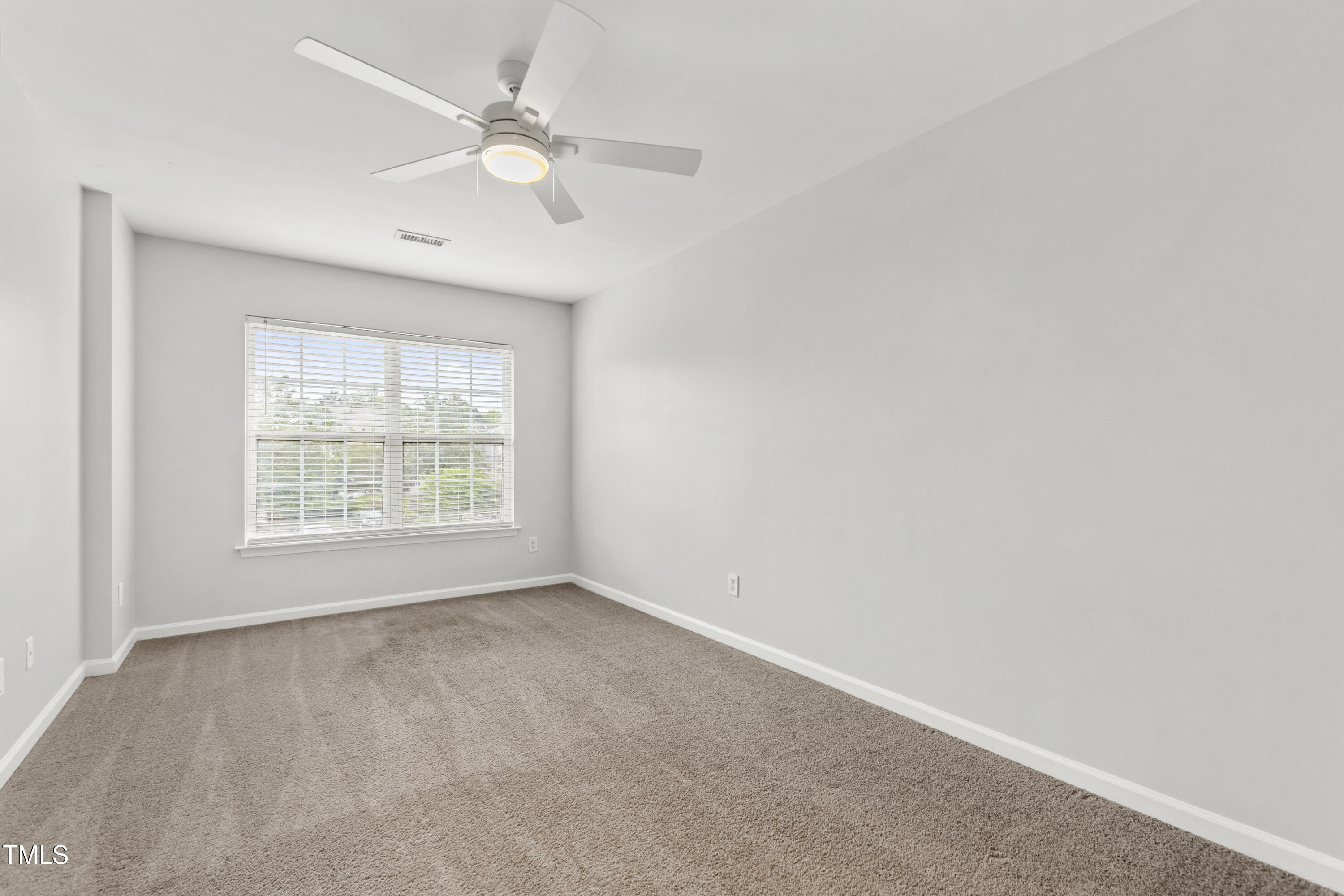 8610 Neuse Landing Lane, Unit 103 Raleigh, NC 27616 - Photo 21 of 28 an empty room with a window and a fan