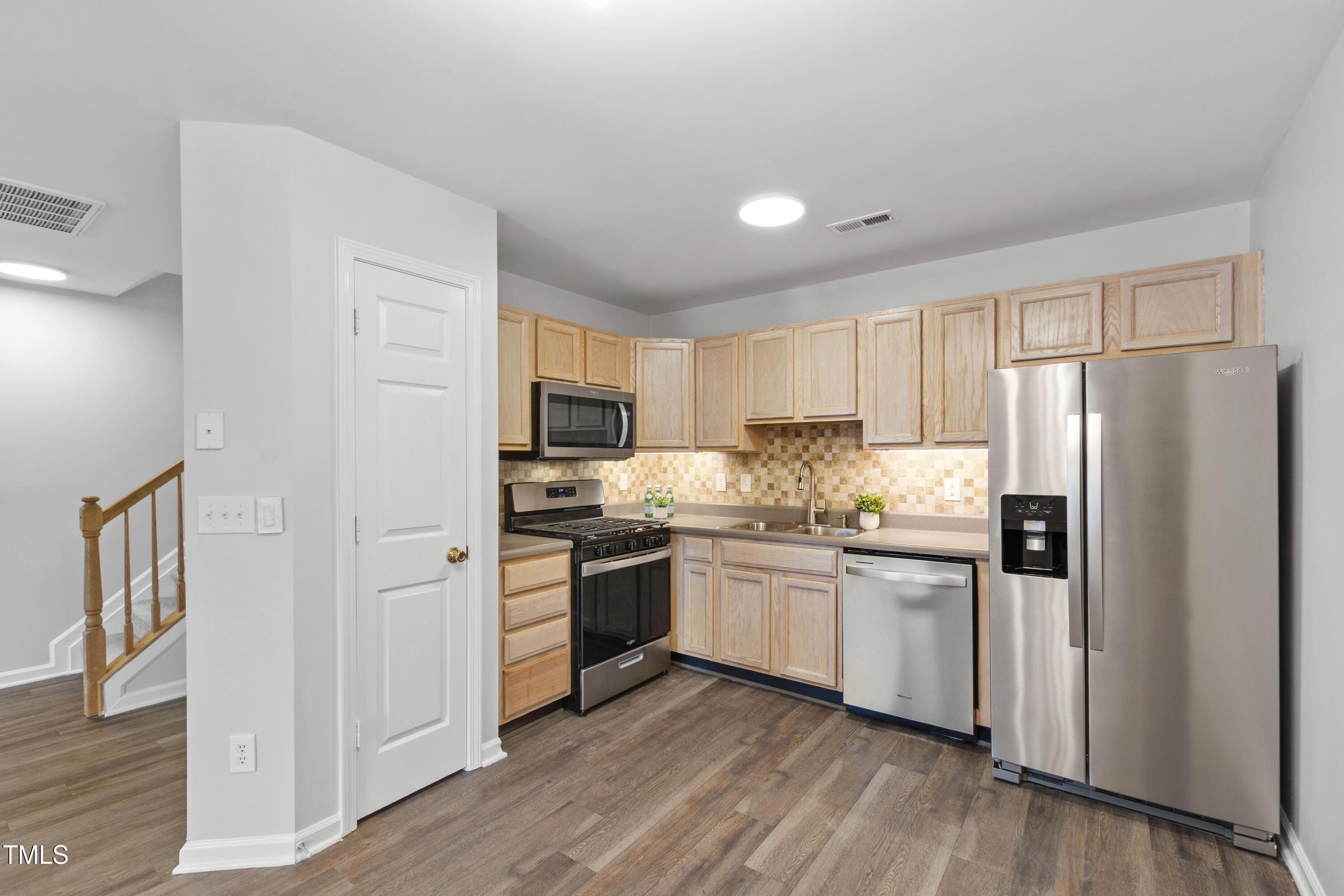 8610 Neuse Landing Lane, Unit 103 Raleigh, NC 27616 - Photo 3 of 28 a kitchen with stainless steel appliances granite countertop a refrigerator stove and sink