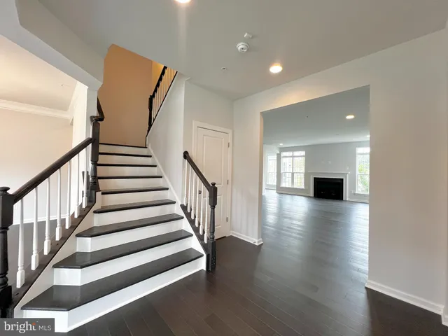 a view of a hallway with wooden floor fireplace and a living room