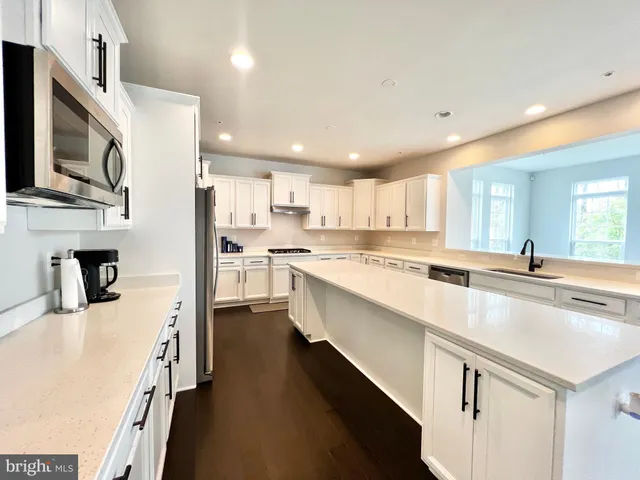 a large kitchen with stainless steel appliances lots of counter space and wooden floor