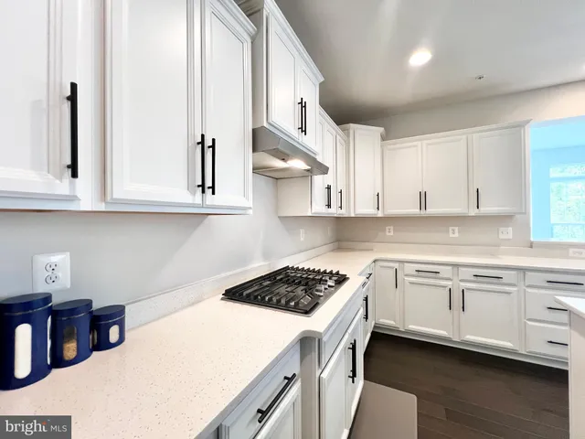 a kitchen with stainless steel appliances granite countertop a sink a stove and cabinets