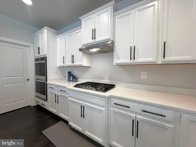 a kitchen with white cabinets and white appliances