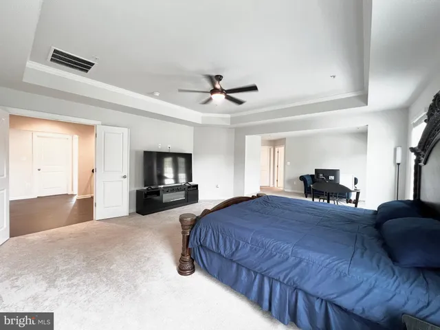 a spacious bedroom with a bed and ceiling fan